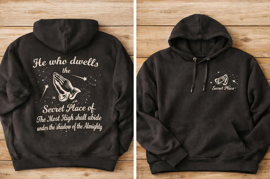 Black hoodie with text and design on the back, displayed on a wooden surface.